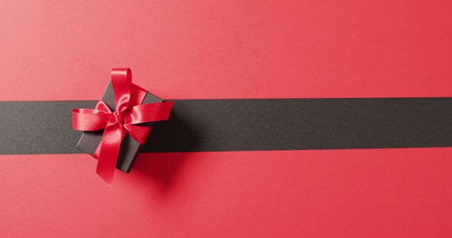 Overhead view of black gift box with red ribbon on black and red background with copy space - Download Free Stock Photos Pikwizard.com