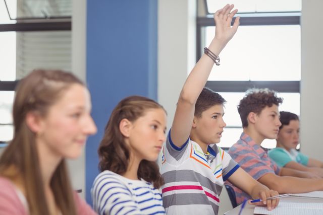 Student raising hand in classroom - Download Free Stock Photos Pikwizard.com