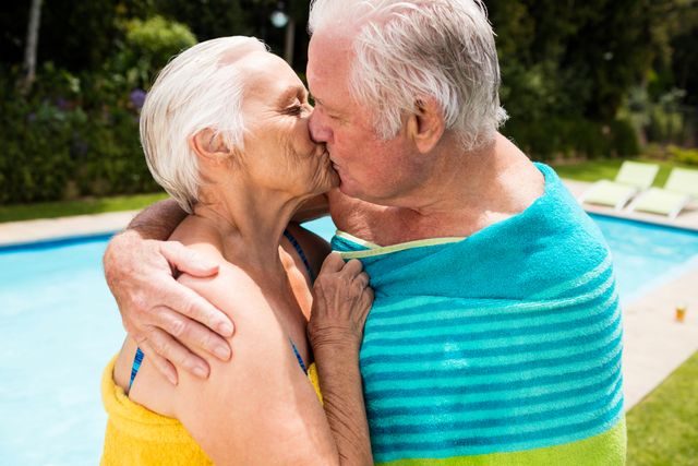 Senior couple kissing each other at poolside - Download Free Stock Photos Pikwizard.com
