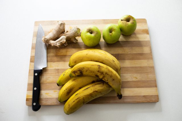 Fruits and ginger with carving knife on wooden chopping board - Download Free Stock Photos Pikwizard.com