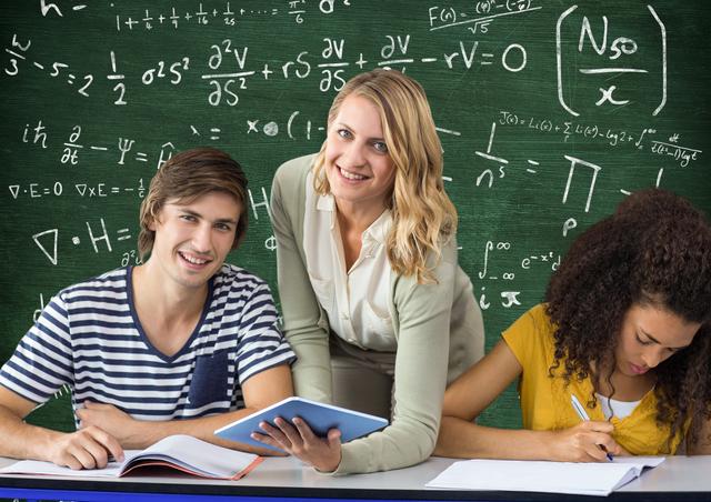 Teacher teaching students against mathematical formulas on green board - Download Free Stock Photos Pikwizard.com