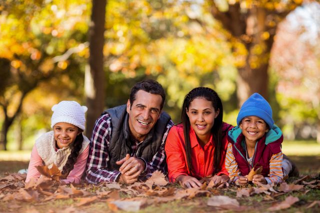 Portrait of cheerful family lying on field during autumn - Download Free Stock Photos Pikwizard.com