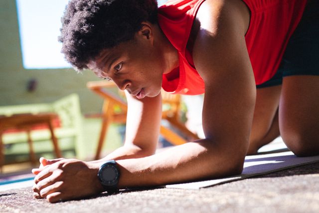 Close-up of african american young man kneeling while exercising at home - Download Free Stock Photos Pikwizard.com