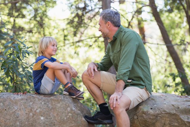 Father and talking while siting on rocks - Download Free Stock Photos Pikwizard.com