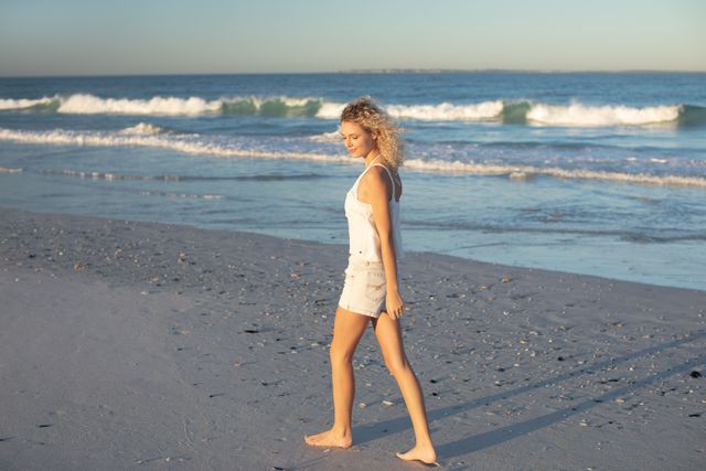 Woman walking barefoot on the beach - Download Free Stock Photos Pikwizard.com