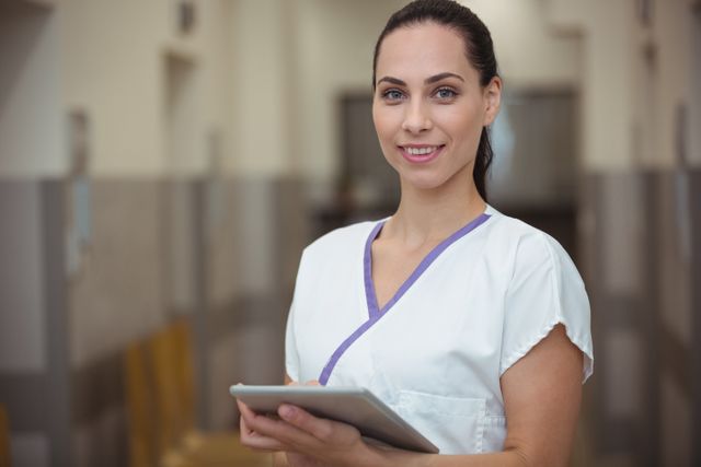 Portrait of female nurse using digital tablet in corridor - Download Free Stock Photos Pikwizard.com