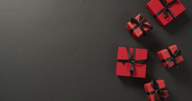 Red gift boxes with black ribbons on black background with copy space - Download Free Stock Photos Pikwizard.com