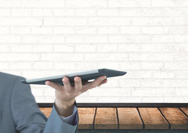 Businessman with tablet against wall - Download Free Stock Photos Pikwizard.com