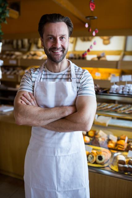 Portrait of smiling owner standing in bakery shop - Download Free Stock Photos Pikwizard.com