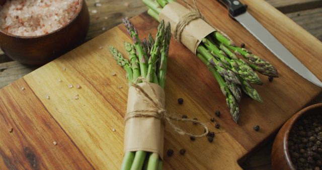 Image of two fresh asparagus bundles on wooden chopping board - Download Free Stock Photos Pikwizard.com