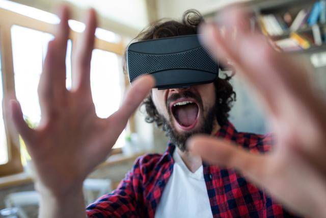 Excited man using virtual reality headset - Download Free Stock Photos Pikwizard.com