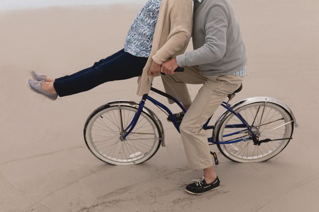 Senior man with senior woman riding bicycle on the beach - Download Free Stock Photos Pikwizard.com
