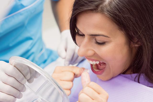 Female patient flossing her teeth - Download Free Stock Photos Pikwizard.com