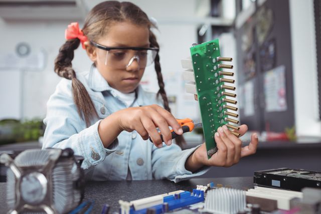 Concentrated elementary girl assembling circuit board - Download Free Stock Photos Pikwizard.com