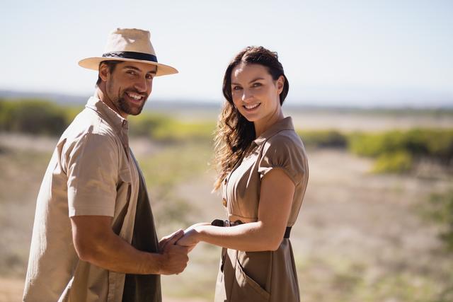 Portrait of smiling couple holding hands during safari vacation