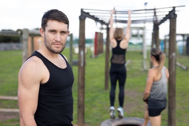 Man looking at the camera while women are training behind - Download Free Stock Photos Pikwizard.com