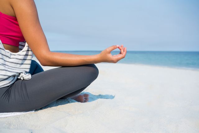 Low section of young woman meditating at beach - Download Free Stock Photos Pikwizard.com