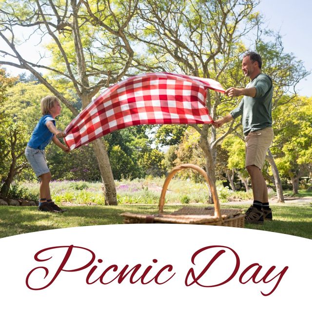 International picnic day text with caucasian father and son laying picnic blanket on grass at park. digital composite, family, bonding, togetherness and holiday concept.
