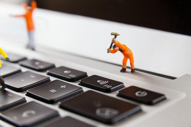 Miniature workmen repairing a laptop keyboard - Download Free Stock Photos Pikwizard.com