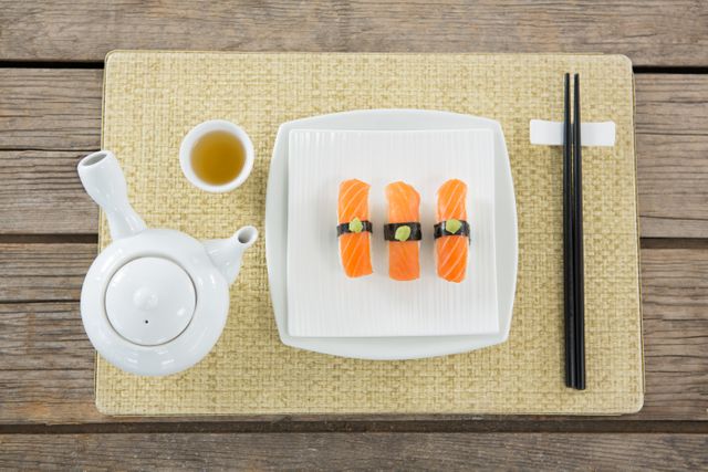 Plate of sushi and tea pot kept on mat - Download Free Stock Photos Pikwizard.com