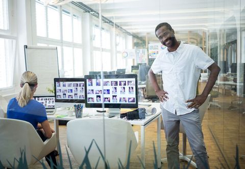 Male business executive standing with hands on hips - Download Free Stock Photos Pikwizard.com