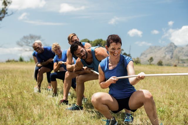 People playing tug of war during obstacle training course - Download Free Stock Photos Pikwizard.com
