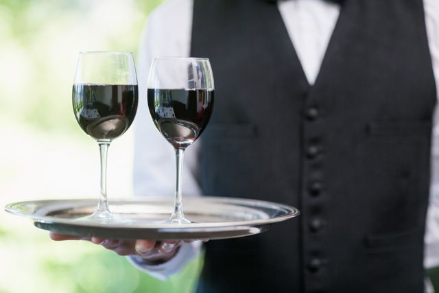 Male waiter holding tray with wine glasses - Download Free Stock Photos Pikwizard.com