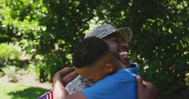 Happy african american soldier father hugging son with flag in garden - Download Free Stock Photos Pikwizard.com