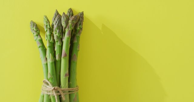 Image of bundle of fresh asparagus with copy space over green background - Download Free Stock Photos Pikwizard.com