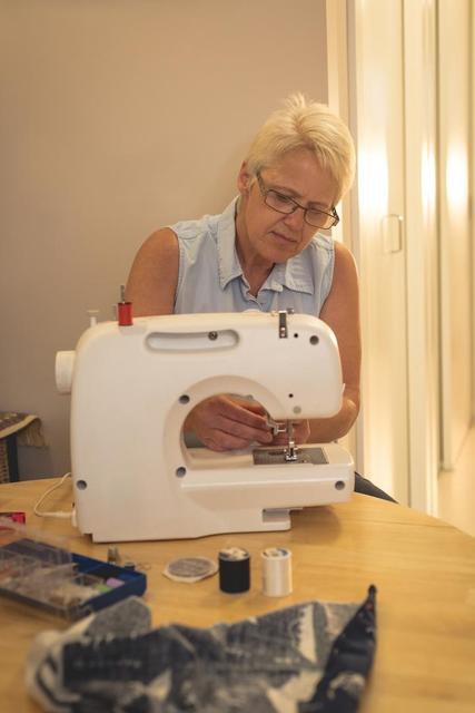 Senior woman using a sewing machine - Download Free Stock Photos Pikwizard.com
