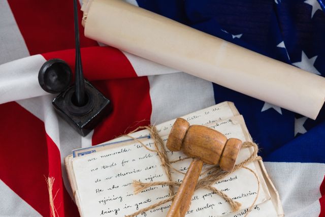 Close-up of gavel with tied up documents arranged on American flag