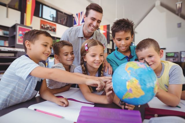 Teacher assisting schoolkids on globe - Download Free Stock Photos Pikwizard.com