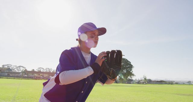 Mixed race female baseball fielder catching and throwing ball on the field. female baseball team, sports training and game tactics.