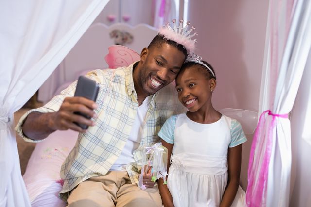 Father and daughter taking selfie while sitting on bed at home - Download Free Stock Photos Pikwizard.com