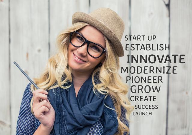 Beautiful woman in hat and spectacle standing against wooden background with motivational text