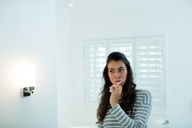 Woman brushing her teeth in bathroom - Download Free Stock Photos Pikwizard.com