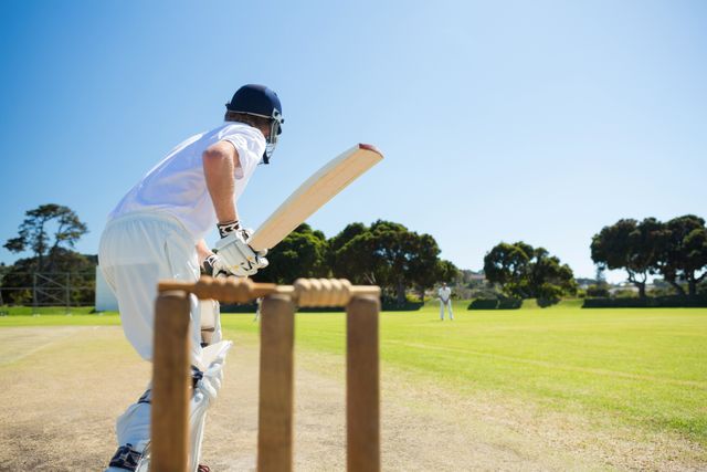 Side view of cricket player batting while playing on field - Download Free Stock Photos Pikwizard.com
