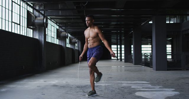 Shirtless african american man skipping the rope in an empty urban building - Download Free Stock Photos Pikwizard.com