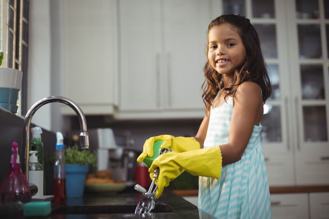 Cute little girl washing utensil in kitchen sink - Download Free Stock Photos Pikwizard.com