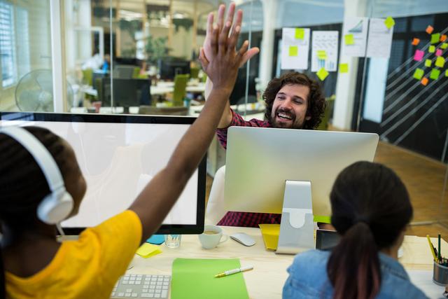 Male graphic designer giving high five to his coworker - Download Free Stock Photos Pikwizard.com