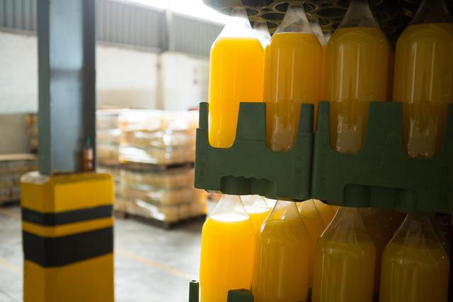 Yellow juice bottles in crate at warehouse - Download Free Stock Photos Pikwizard.com