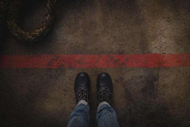 Person standing near the red marking line - Download Free Stock Photos Pikwizard.com