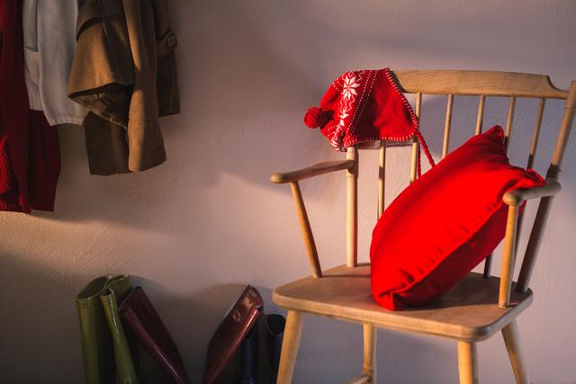 Wooden chair with red pillow and winter hat - Download Free Stock Photos Pikwizard.com