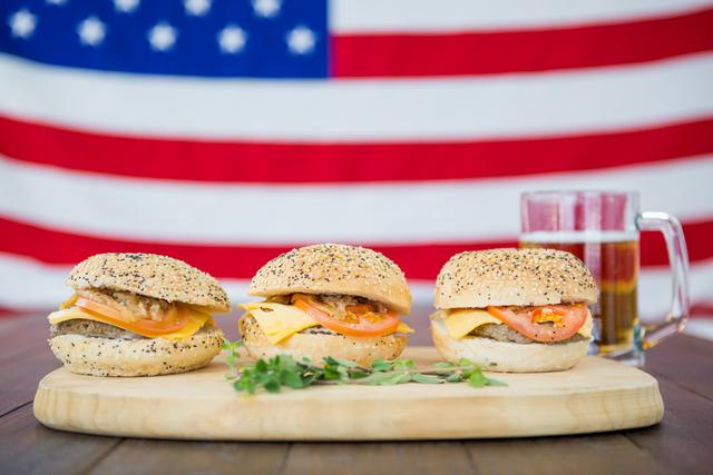 Three hamburger and a beer mug against USA flag background