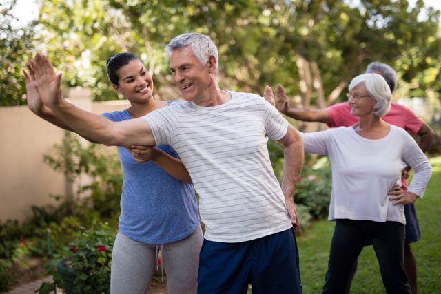 Happy trainer teaching senior people while exercising - Download Free Stock Photos Pikwizard.com