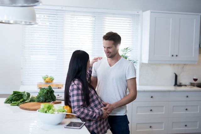 Man touching womans pregnant belly in the kitchen - Download Free Stock Photos Pikwizard.com