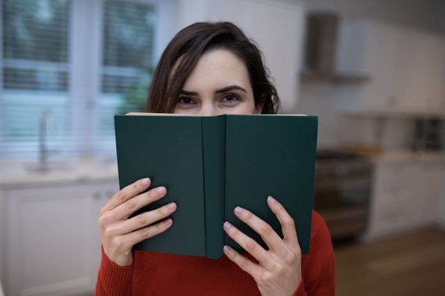 Beautiful woman covering her face with book - Download Free Stock Photos Pikwizard.com