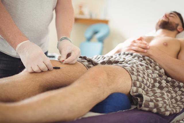Physiotherapist performing dry needling on the knee of a patient - Download Free Stock Photos Pikwizard.com