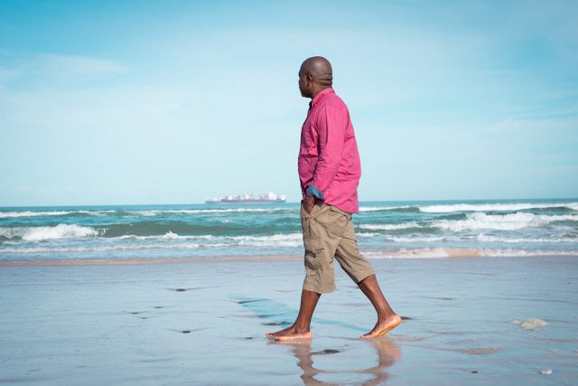 African american senior man walking at beach and looking at sea - Download Free Stock Photos Pikwizard.com
