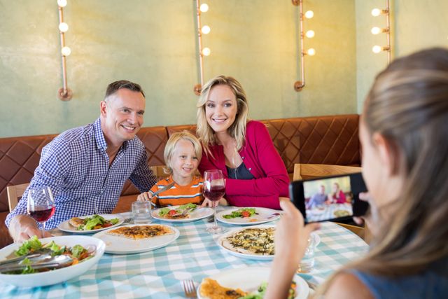 Girl photographing family through smart phone - Download Free Stock Photos Pikwizard.com